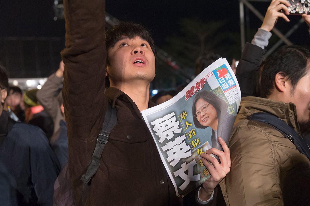  2016年1月16日，台北，民进党总统候选人蔡英文当选总统，支持者手持当日出版的晚报参与祝捷晚会。摄：张国耀/端传媒