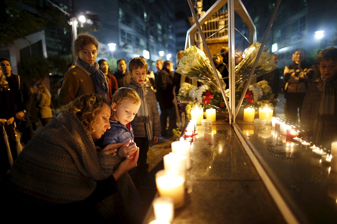 2015年11月14日，韩国首尔母亲一名与孩子点起蜡烛悼念巴黎恐怖袭击的遇难者。摄：Kim Hong-Ji/REUTERS