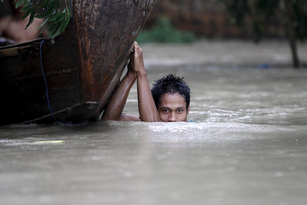 男子在缅甸水浸灾区拉动他的小艇。摄: Soe Zeya Tun /REUTERS