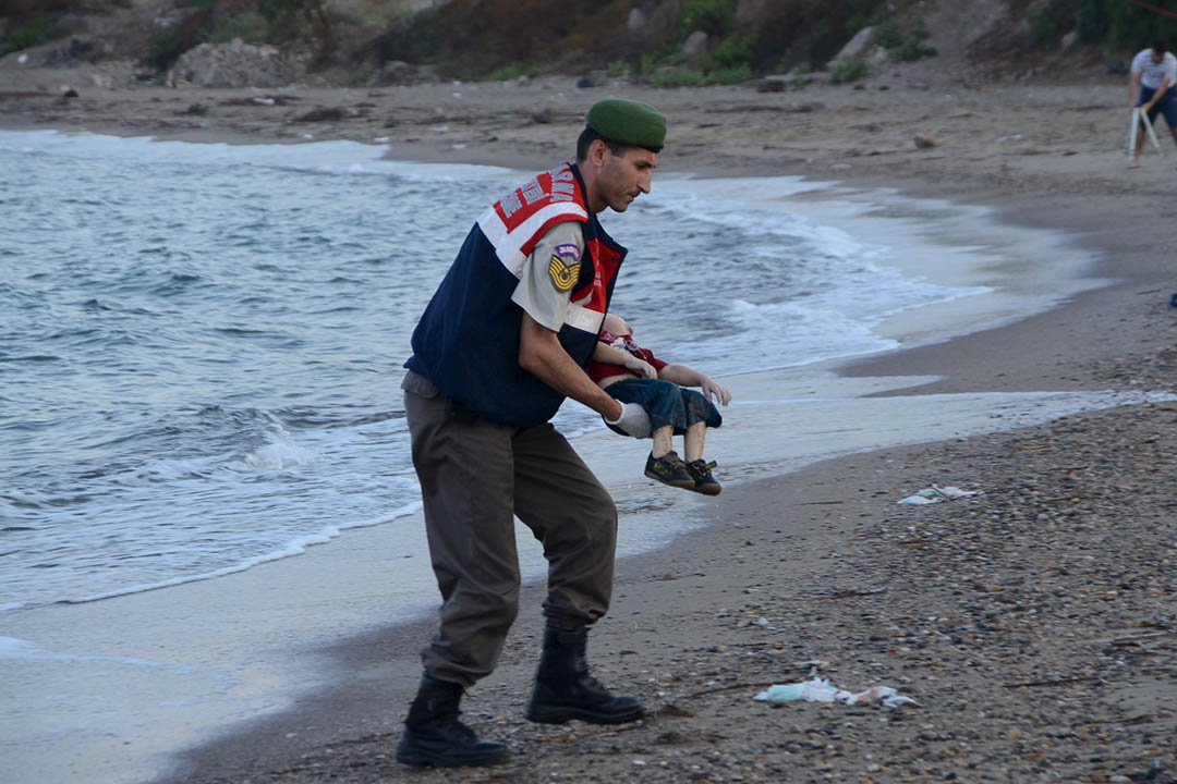 三岁难民 Aylan Kurdi 与其他11名叙利亚难民乘坐偷渡船前往土耳其时遇难，被发现伏尸沙滩上。摄：Nilufer Demir/DHA/REUTERS