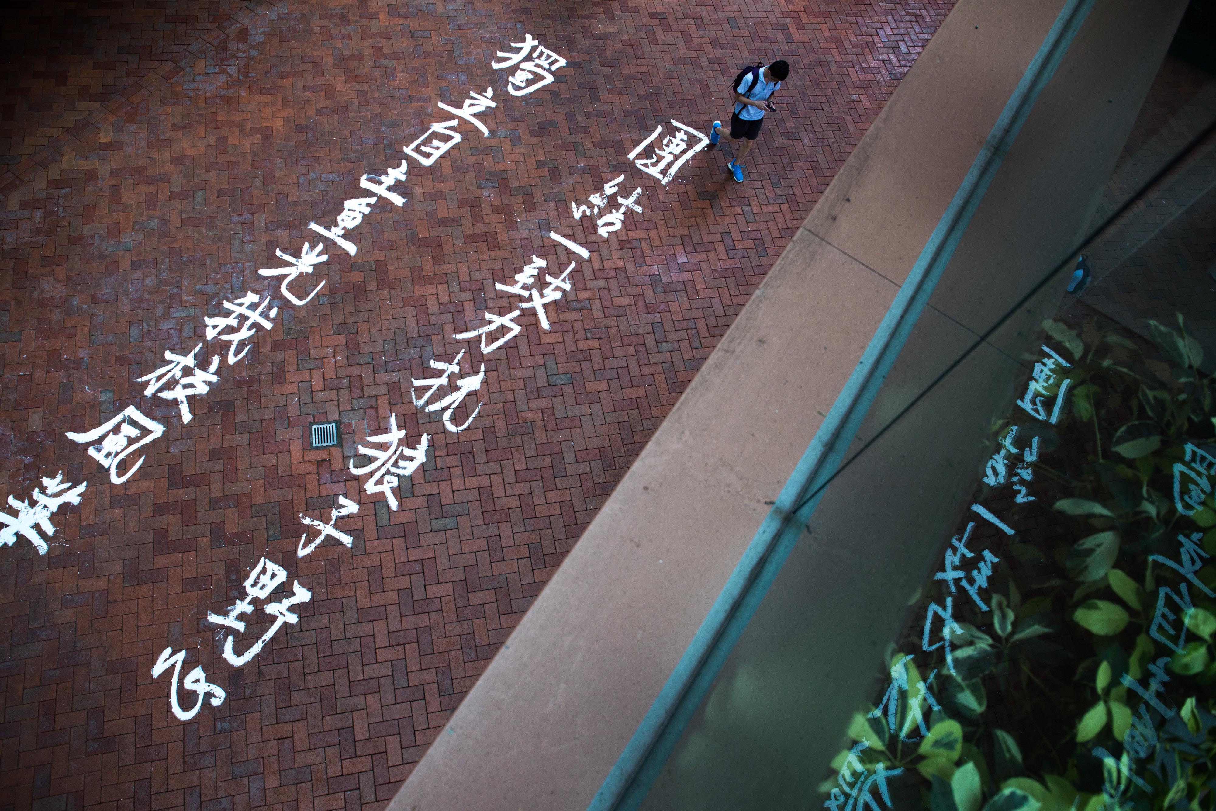 港大校园地上写有「团结一致力 抗狼子野心，独立自主重光我校风华」的字句。摄：卢翊铭/端传媒