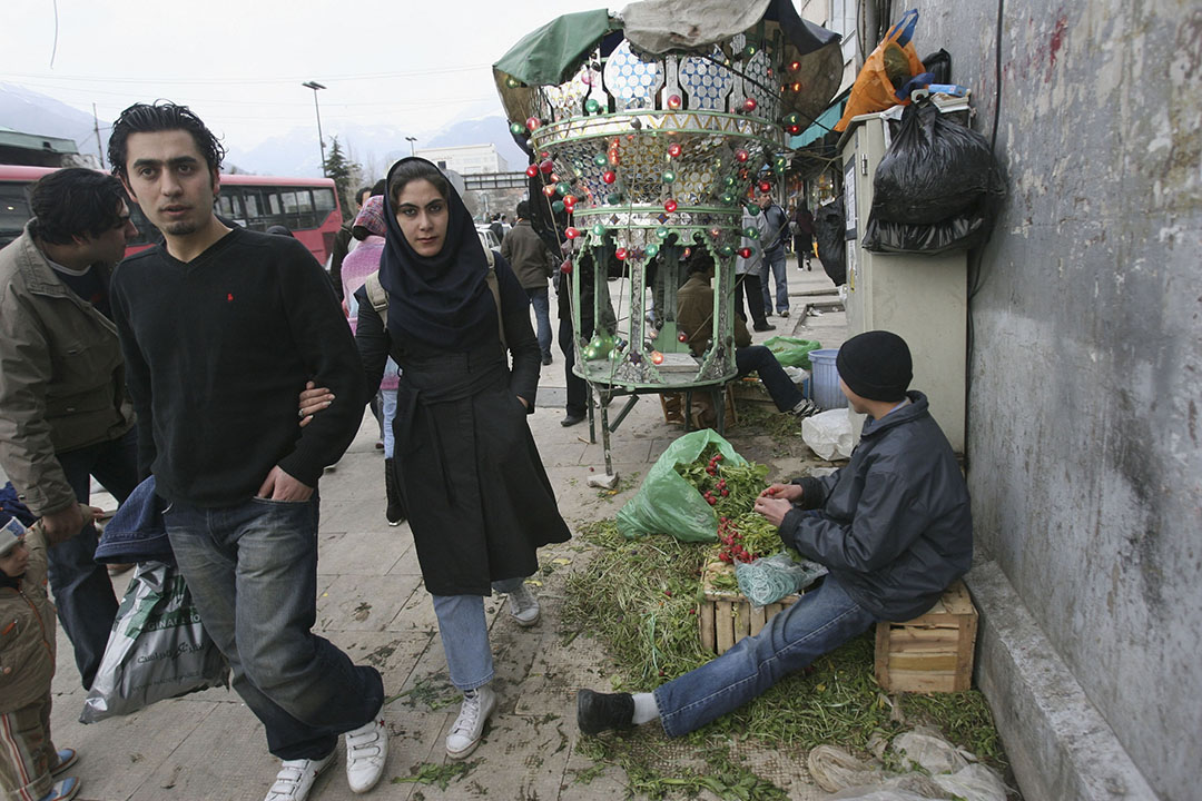 一 对 情侣在伊朗德克兰逛街， 路边有摆档的小贩。摄：Majid Saeedi/GETTY