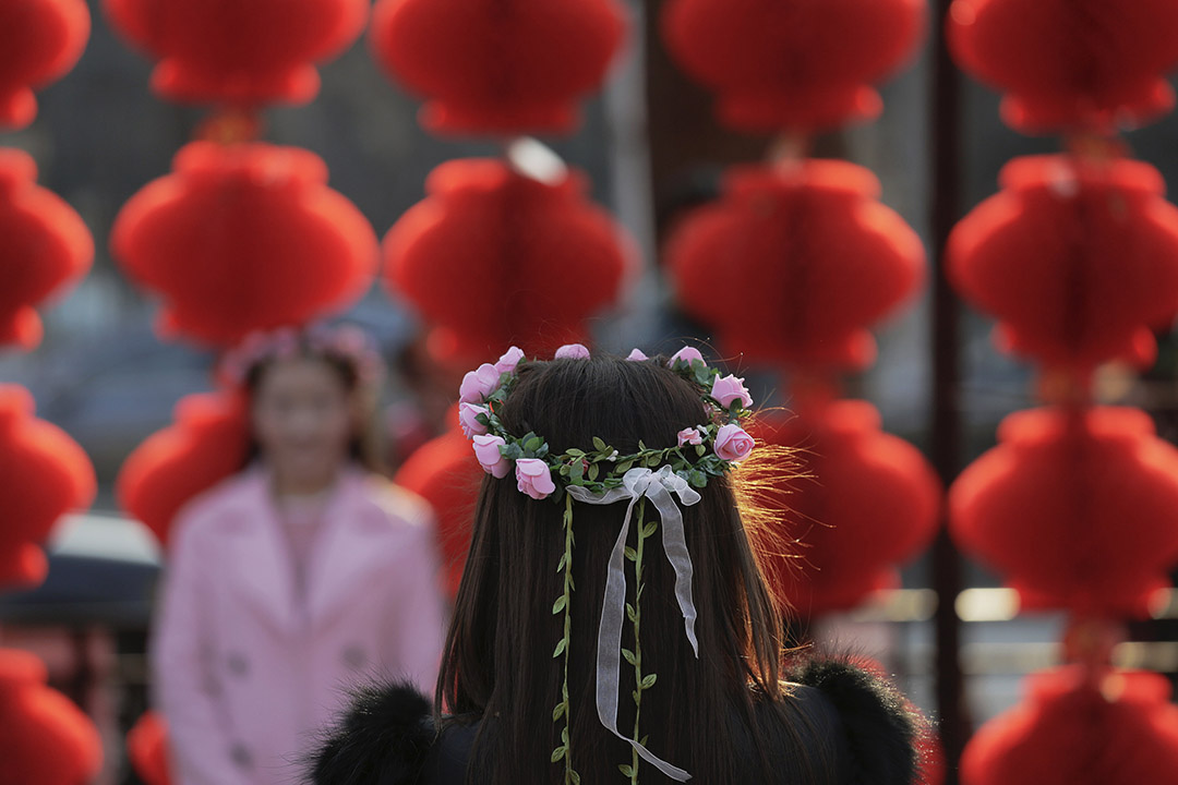  2016年2月9日，北京，一名女士在农历新年期间再龙潭公园为女友人拍照。摄：Damir Sagolj/REUTERS