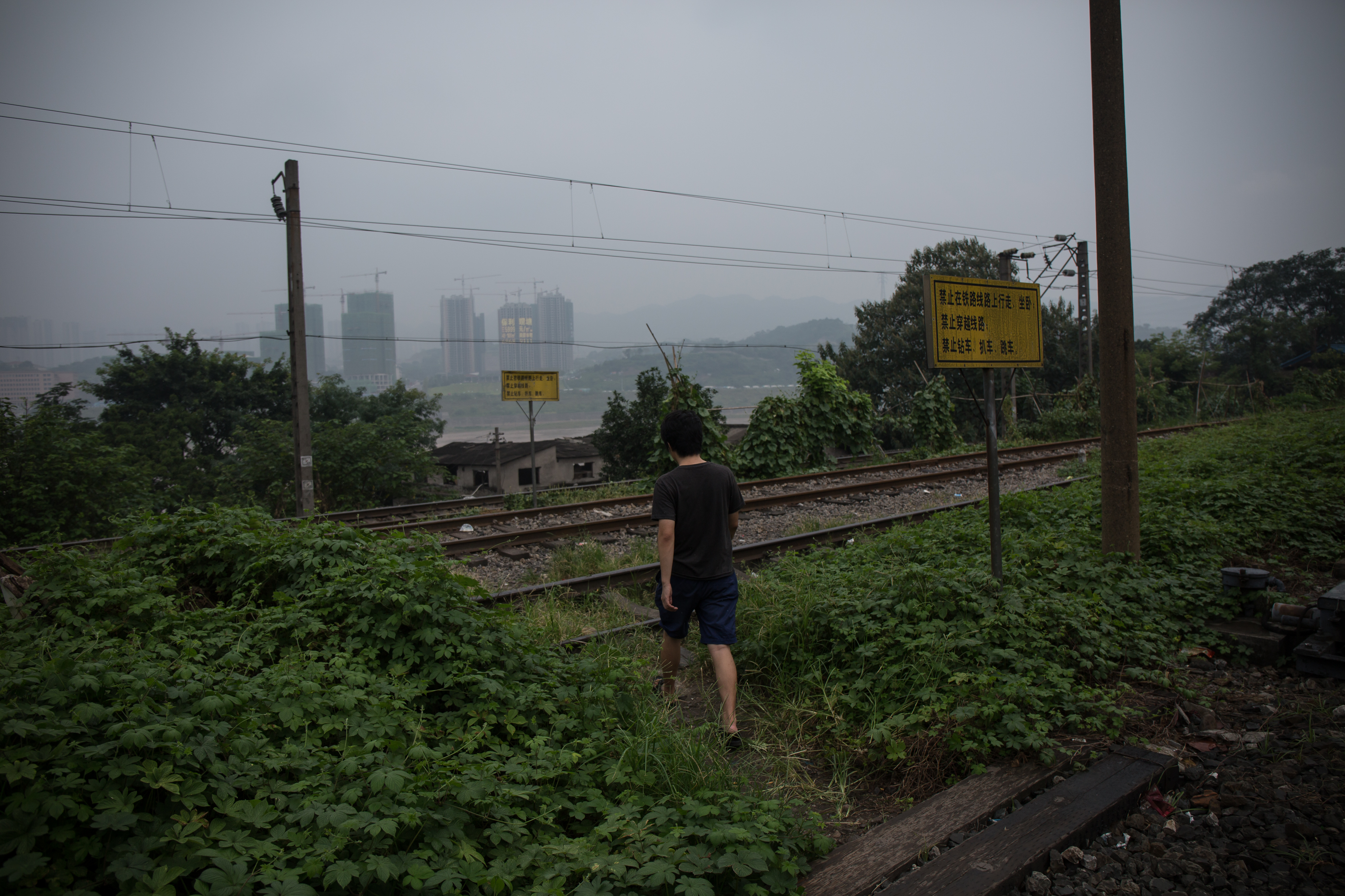 劉偉偉走過火車路軌。攝: Billy H.C. Kwok/ 端傳媒