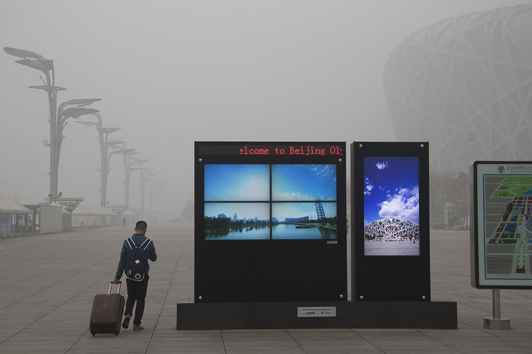 旅客抵达鸟巢体育馆，欢迎标语下的蓝天白云北京城，在雾霾中特别抢眼。摄:China Daily/REUTERS