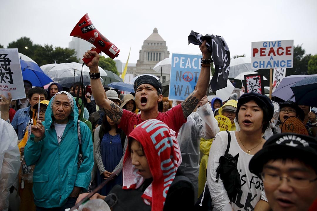 示威者在国会大楼前抗议，反对首相安倍晋三推动的安保法案。 摄 : Thomas Peter/REUTERS