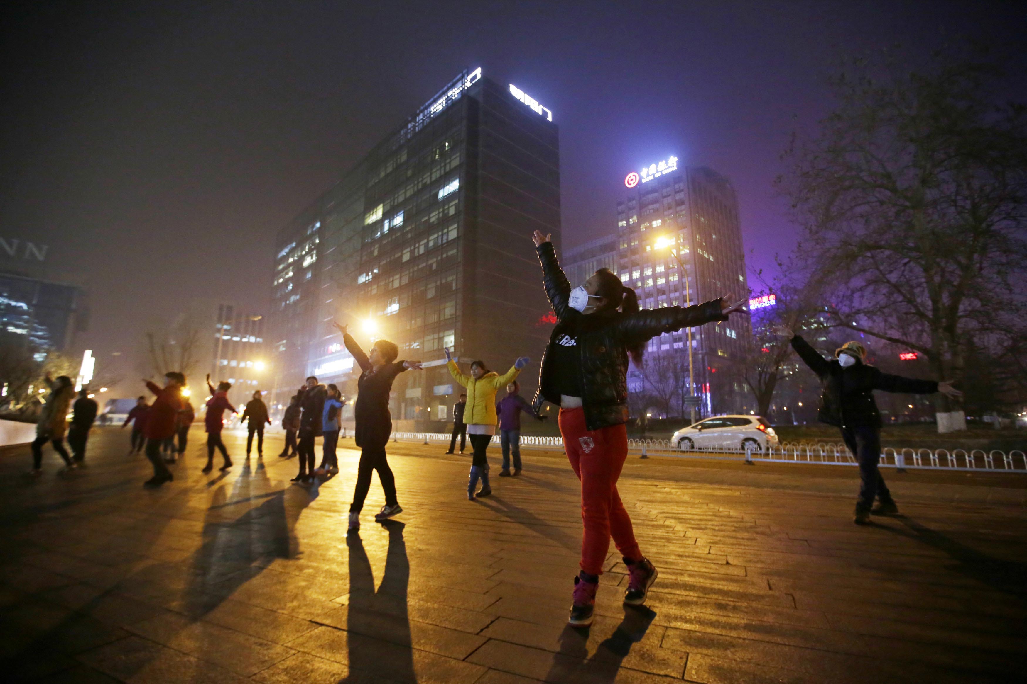 北京一个广场，大妈在雾霾天气中跳舞。摄：Jason Lee/REUTERS